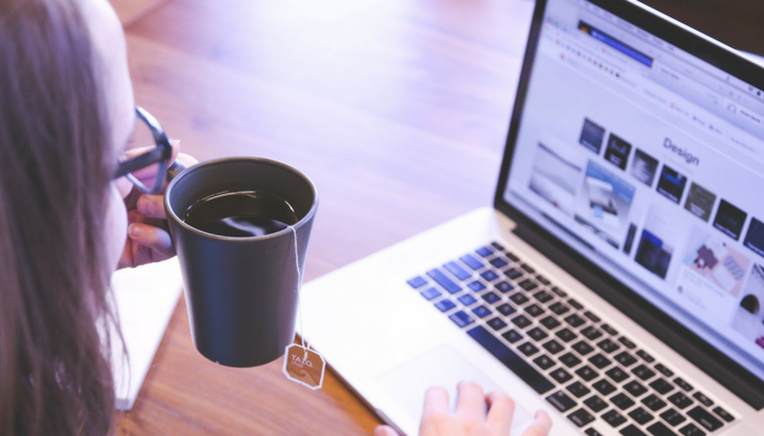 Using a laptop with a cup of tea